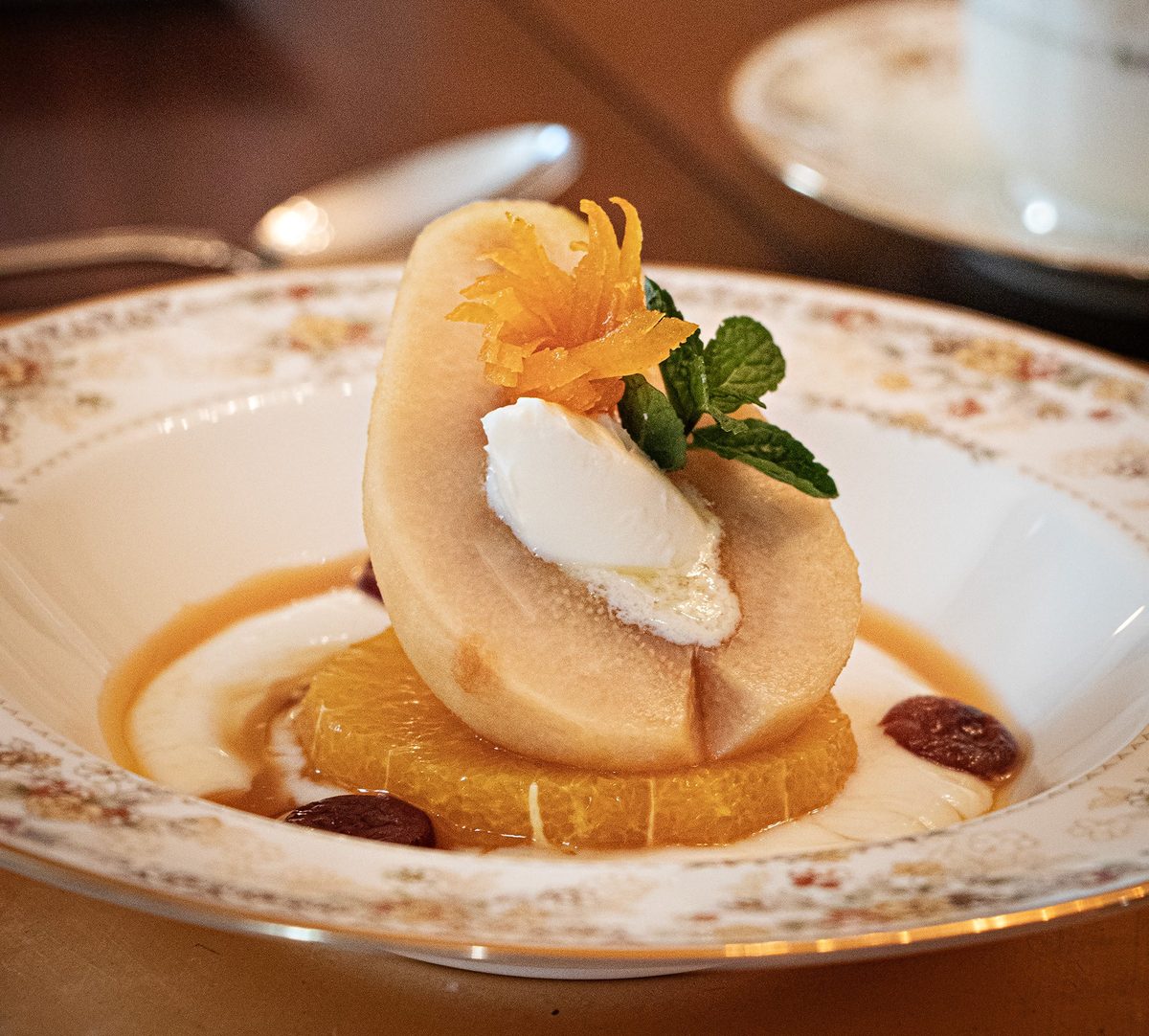 Second course — poached pear with cream and mint on citrus