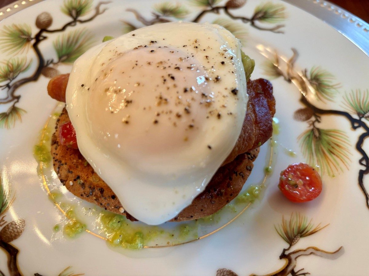 Third course — poached egg on everything bagel with bacon, avocado, pesto, and roasted tomato
