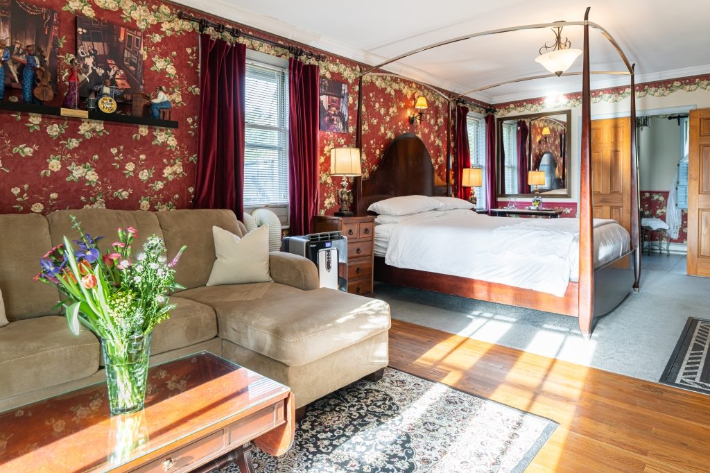 All That Jazz suite — king canopy bed and sofa seating area at The Reynolds Mansion Carriage House, Asheville