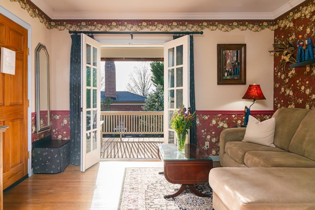 All That Jazz suite — sitting area with French doors open to private balcony at The Reynolds Mansion