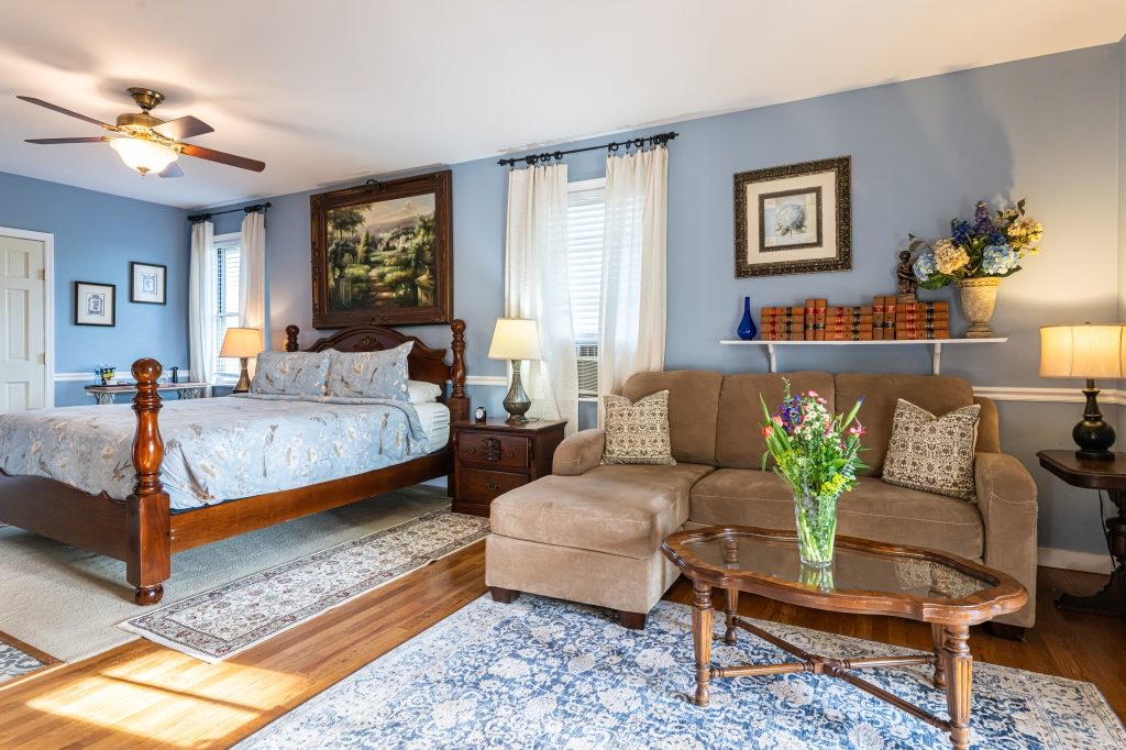 Blue Hydrangea suite — king bed and sitting area with sofa at The Reynolds Mansion Carriage House, Asheville