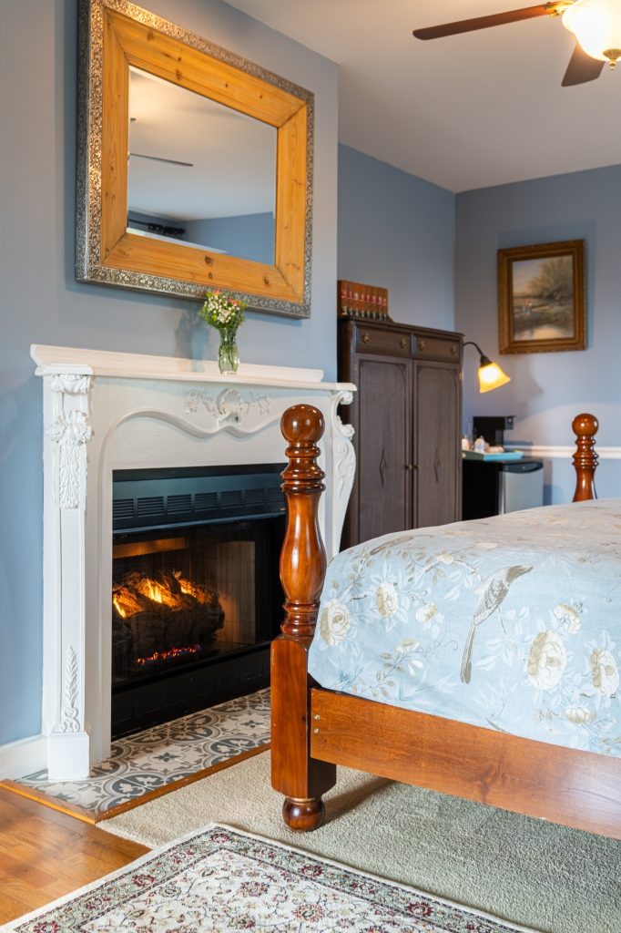 Blue Hydrangea suite — fireplace mantel with carved mirror at The Reynolds Mansion Carriage House