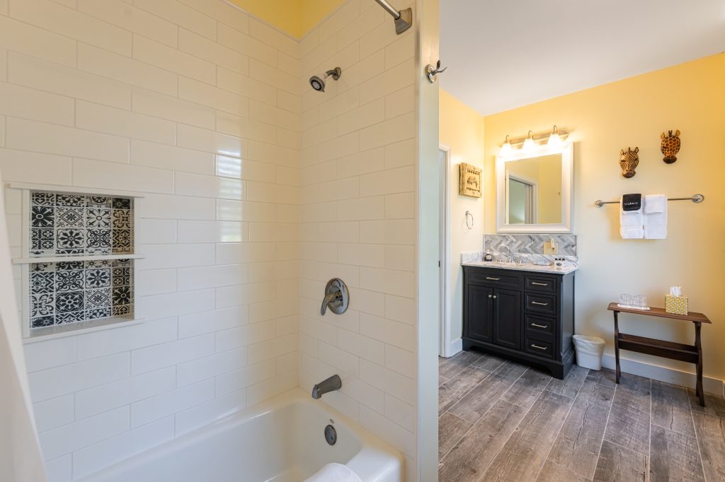 Elephant Walk suite — private bathroom with subway tile shower and tub combo at The Reynolds Mansion