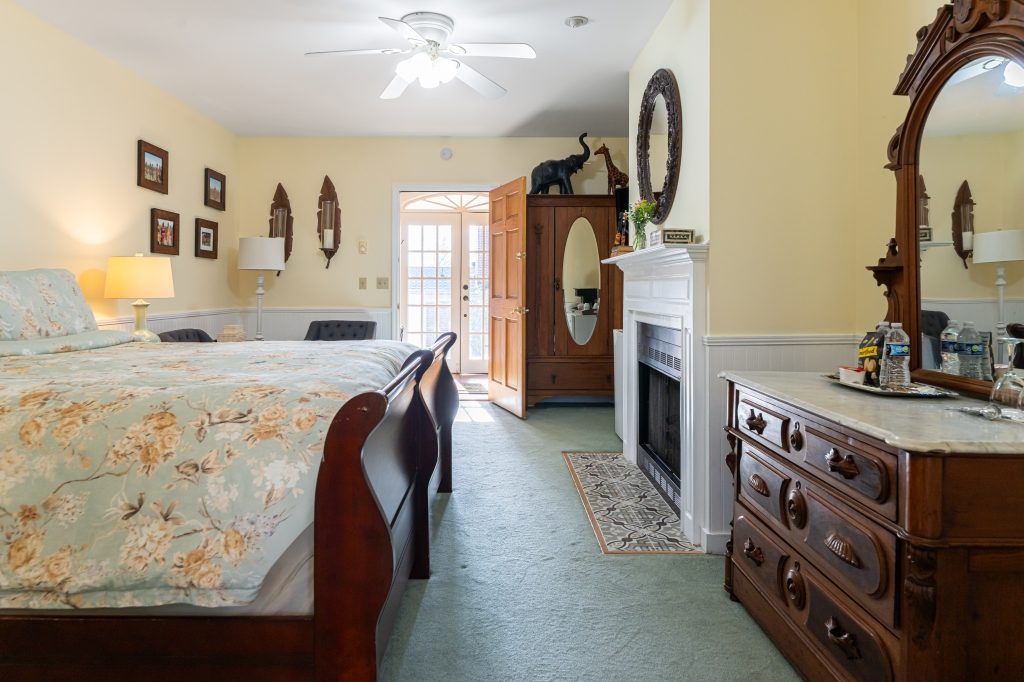 Elephant Walk suite — king sleigh bed with fireplace and French doors to private deck at The Reynolds Mansion Carriage House, Asheville