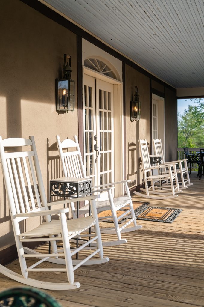 Row of white rocking chairs on the Carriage House covered porch
