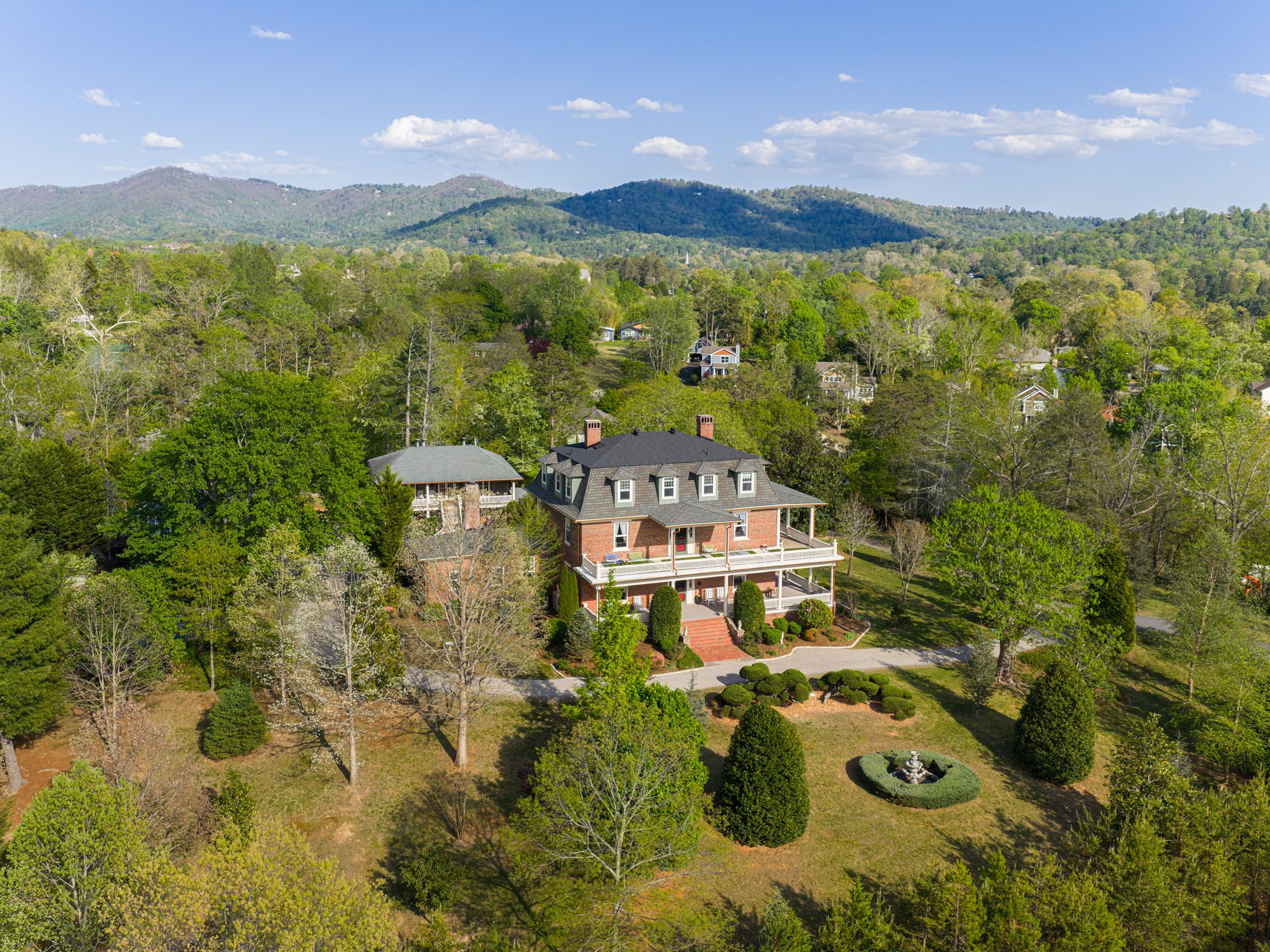 Aerial view of The Reynolds Mansion with the Blue Ridge Mountains beyond — the kind of morning a third night was made for