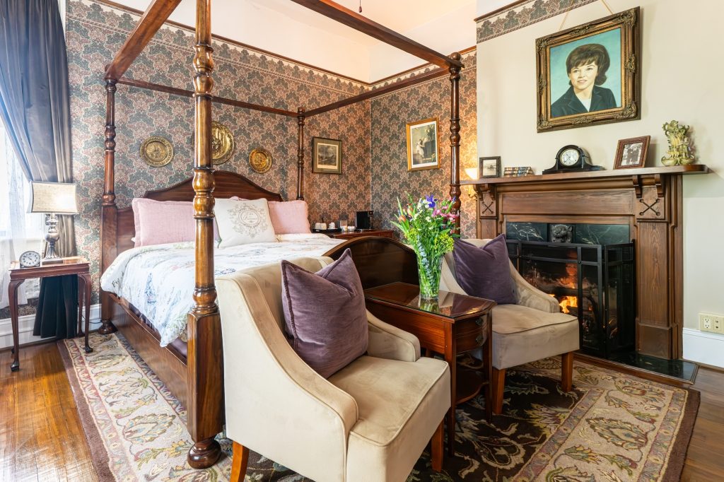 Linda room — king four-poster canopy bed with sitting area at The Reynolds Mansion
