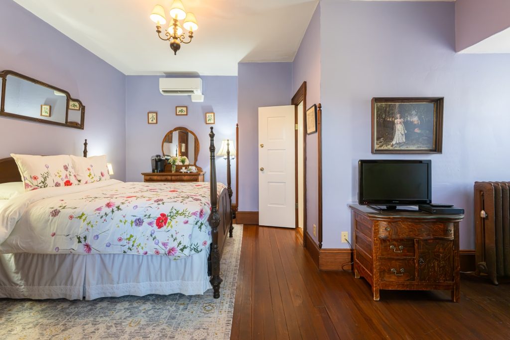 Maggie room — wider view showing bed, dresser, and antique furnishings at The Reynolds Mansion