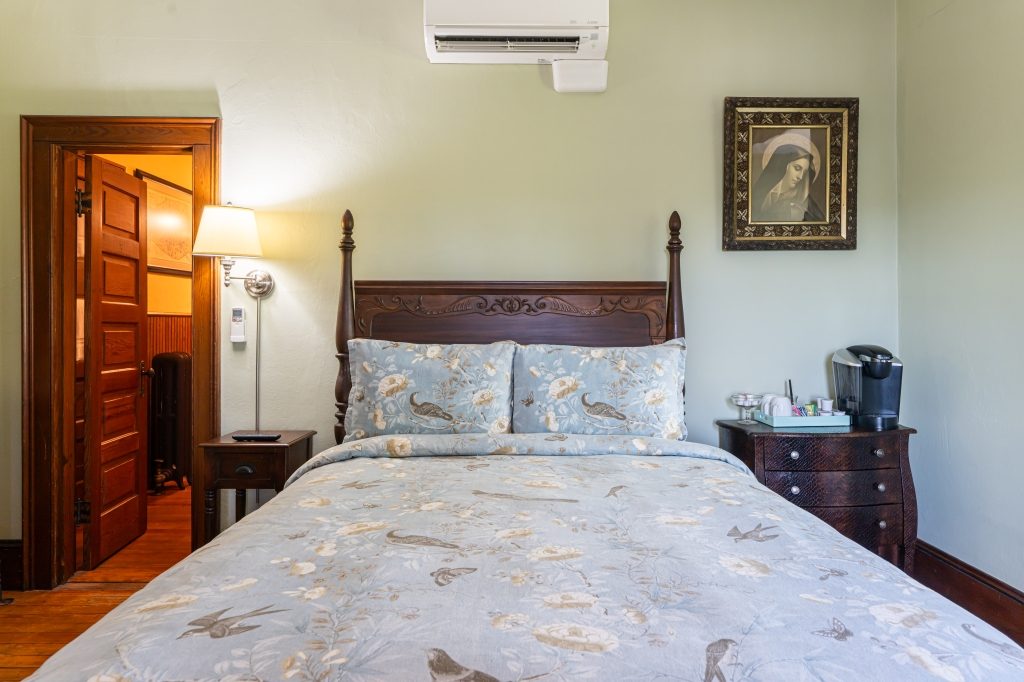 Vera room — bed close-up with bird and butterfly bedding at The Reynolds Mansion