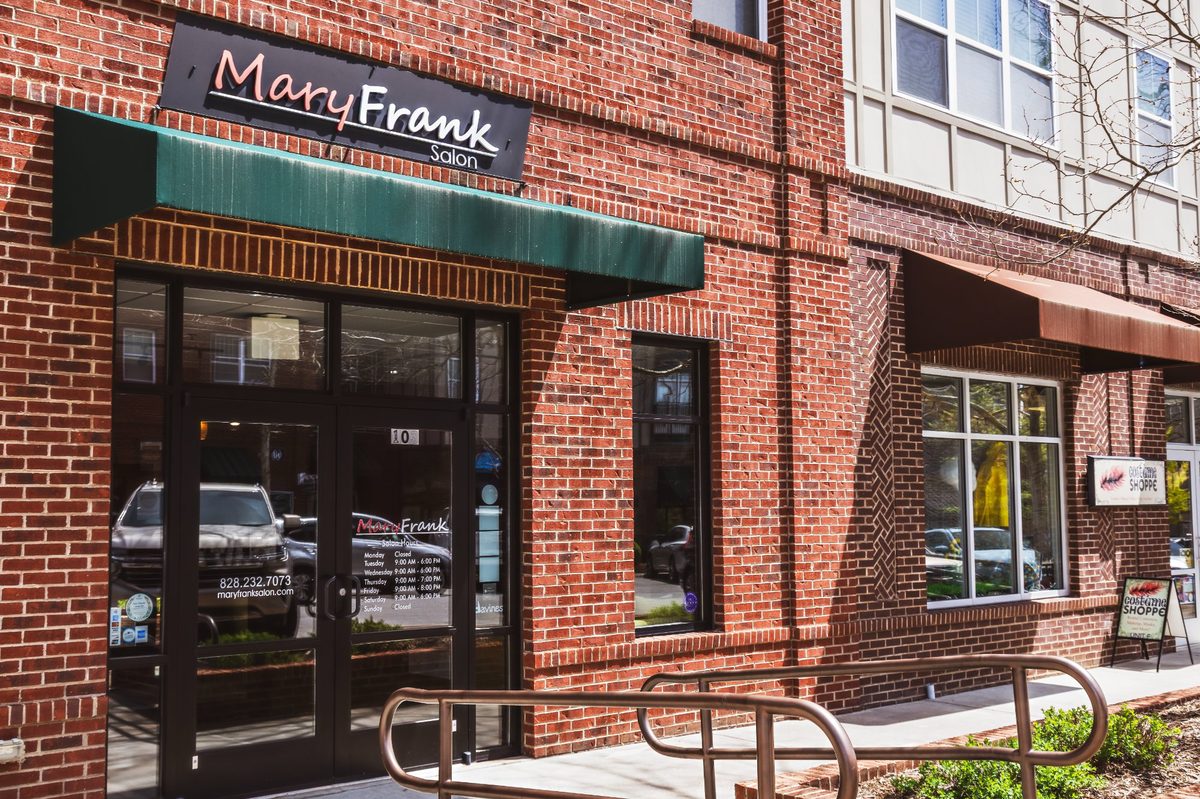 Mary Frank Salon exterior in Reynolds Village — brick building with green awning