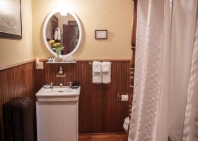  A bathroom with a toilet, sink, and mirror.