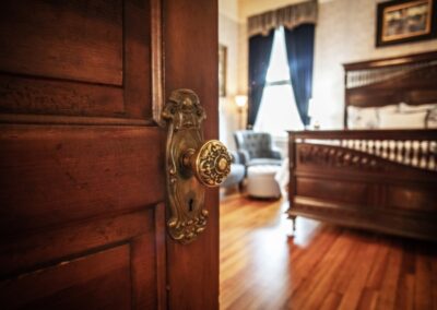 An ornate door handle on an open wooden door.