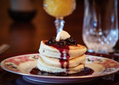 A stack of pancakes topped with blueberry sauce.