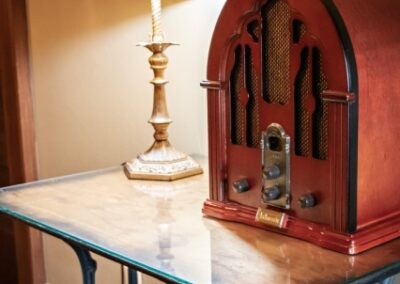 Vintage radio on a marble-top table beside a lamp.